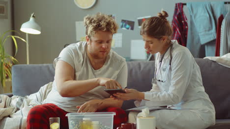 ill man talking with female doctor at home