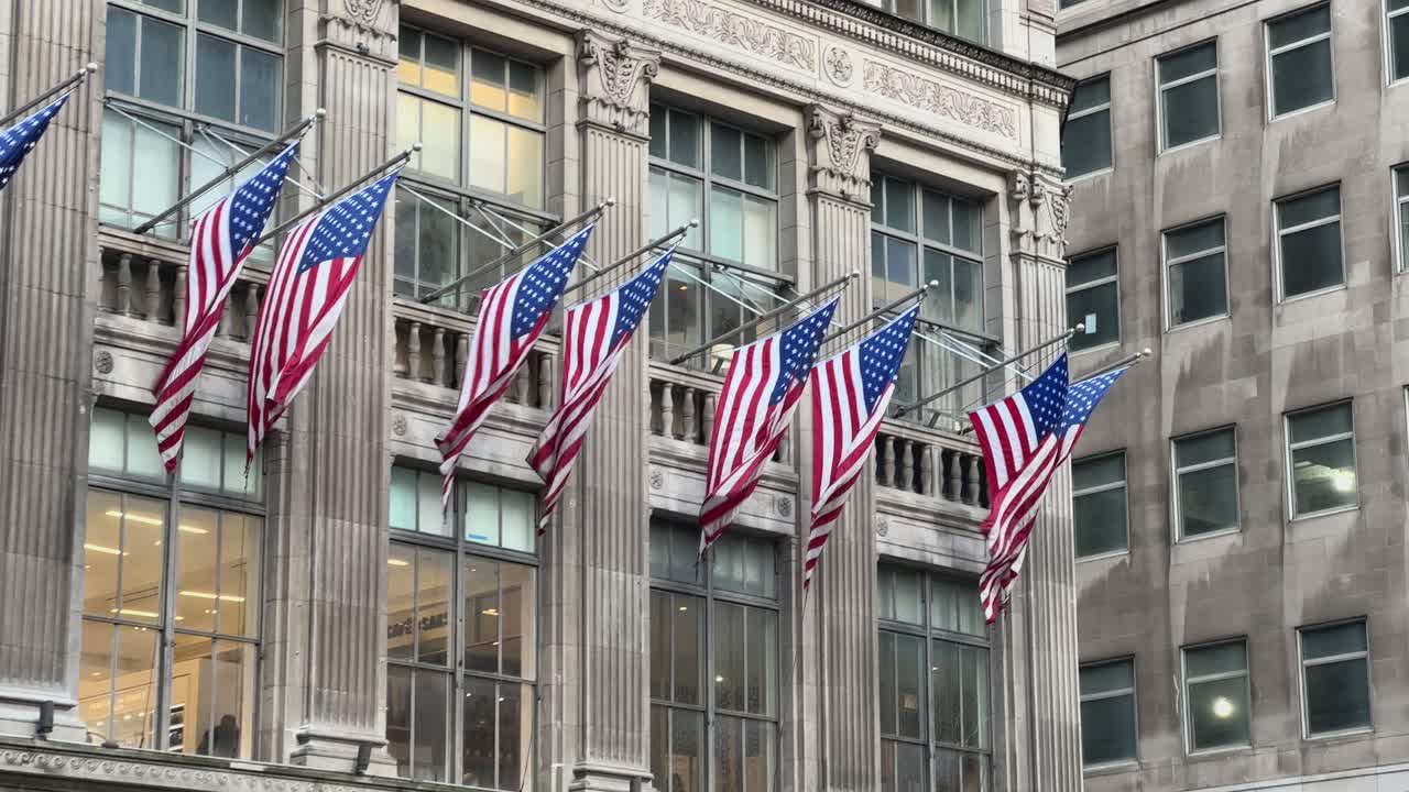 Bandiere americane sventolano sull'esterno di un edificio della 5th Avenue a Manhattan, New York City, USA