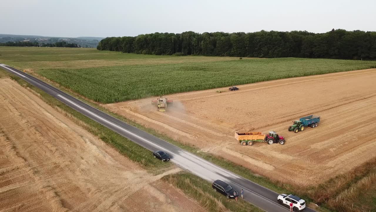 una toma cinematográfica de 4k de múltiples maquinaria agrícola trabajando en un campo en francia, mostrando una vista épica del paisaje agrícola