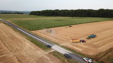 a cinematic 4k drone shot of multiple agriculture machinery working in a field in france, showcasing an epic view of the farming landscape