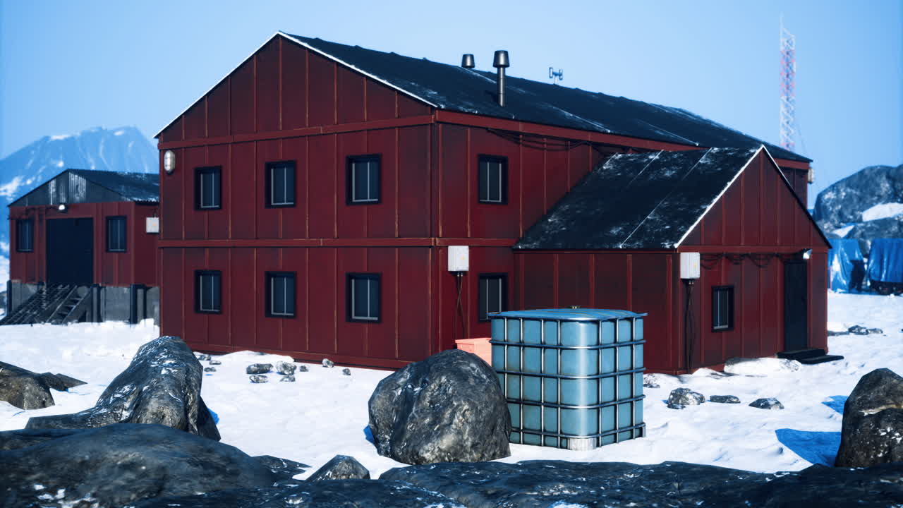 Snow covered red buildings near rocky landscape in a cold icy environment