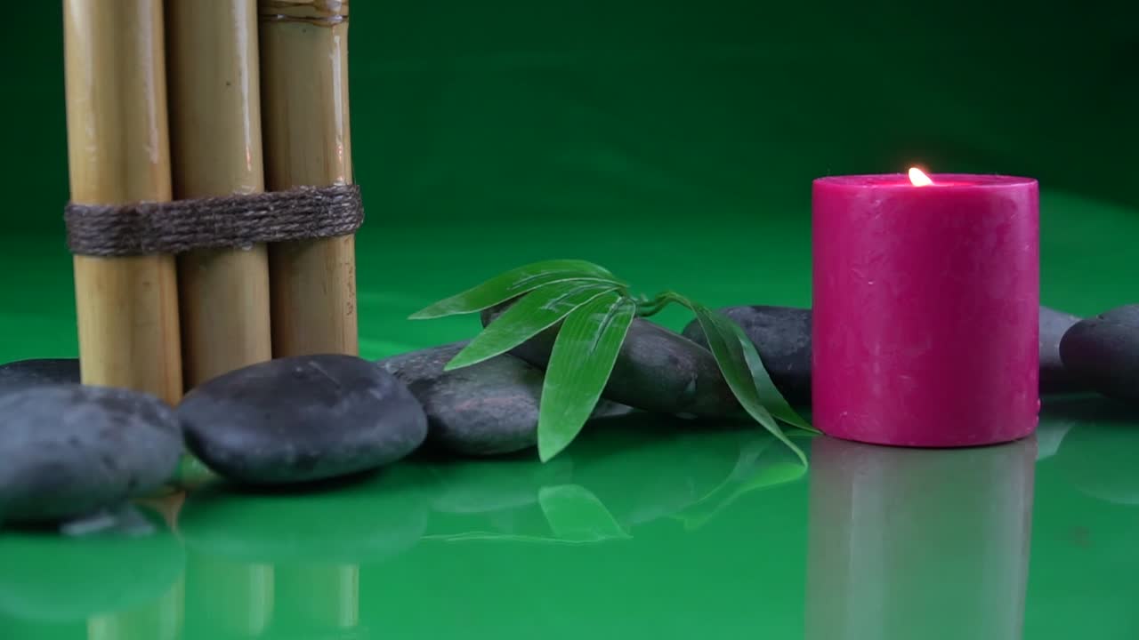 평온과 평화를 부르는 대나무 줄기 잎과 붉은 촛불