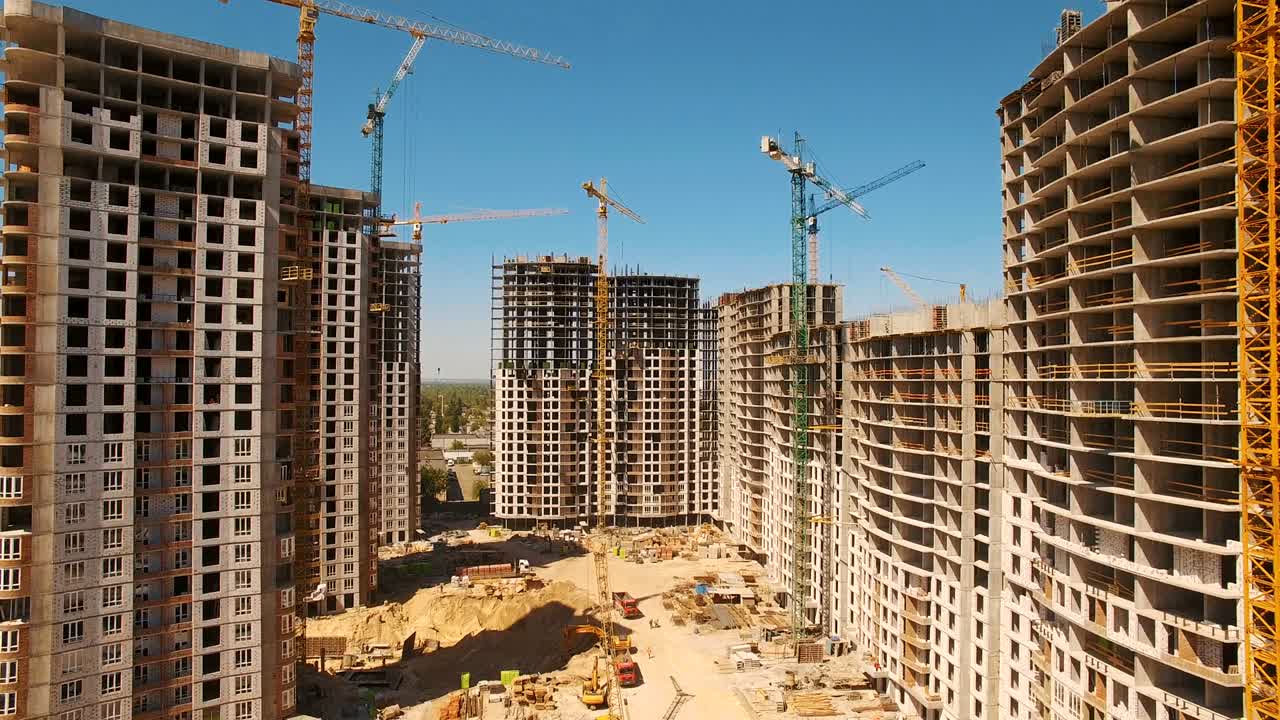 construcción de casas. aviones no tripulados vuelan sobre el sitio de construcción con grúas torre