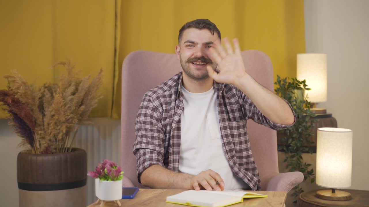 человек, машущий камере.