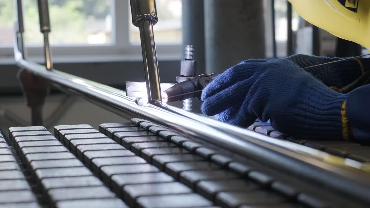 Man wearing mask welding in a workshop. Metal workers use manual labor. Skilled welder. Welder is welding the stainless steel pipes in the factory. welder Industrial part in factory.