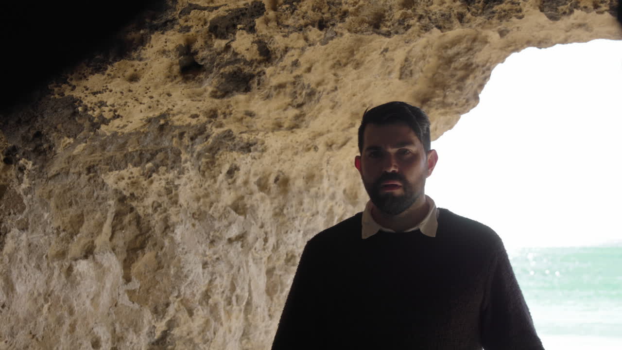 Man in Cave Overlooking Ocean