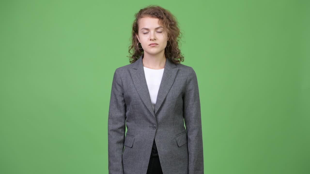 Happy young beautiful businesswoman pointing up