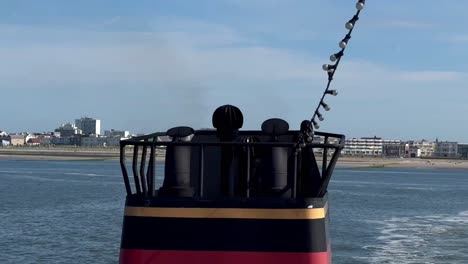 close up shot of rising smoke of funnel on ferry ship on sea and norderney island in background, germany