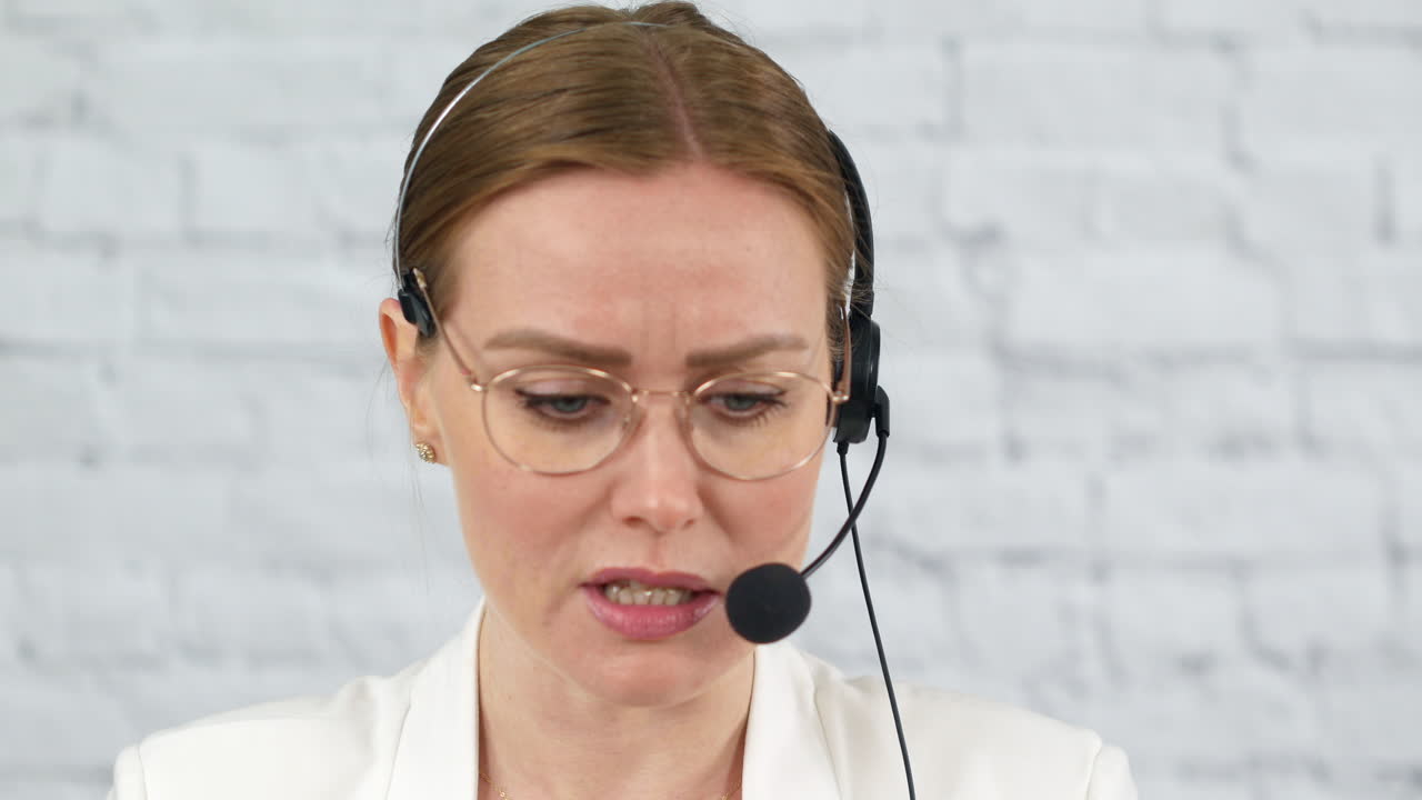 Kvinnelig kundeservicemedarbeider som jobber på et kontor med et hodesett med mikrofon