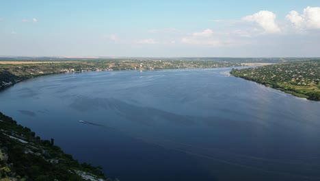 drone flying over golden glow on dniester river surface that flows with grace and majesty between molovata village banks