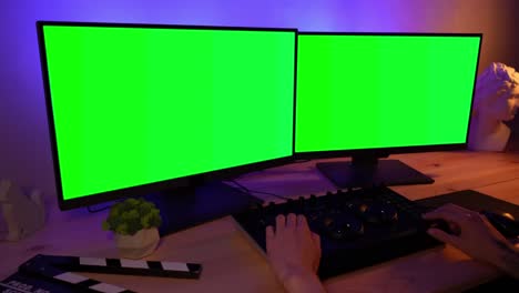 video editor at work with green screen monitors
