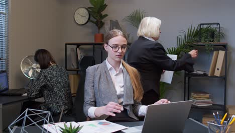 young businesswoman meditates holds mind under control practices yoga makes zen gesture in office