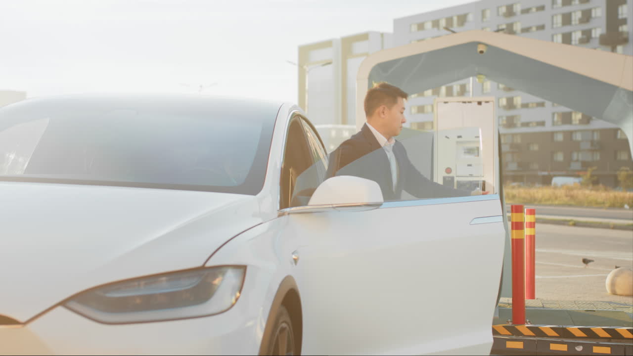 충전소 에서 전기 차량 을 충전 하는 사람