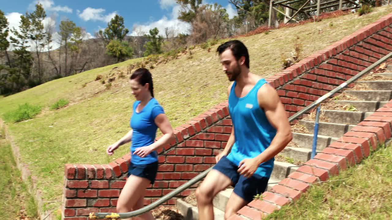 hombre y mujer en forma haciendo ejercicio durante una carrera de obstáculos