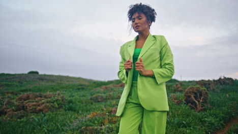 sad african woman walking cloudy field. girl feeling cold outdoor vertically