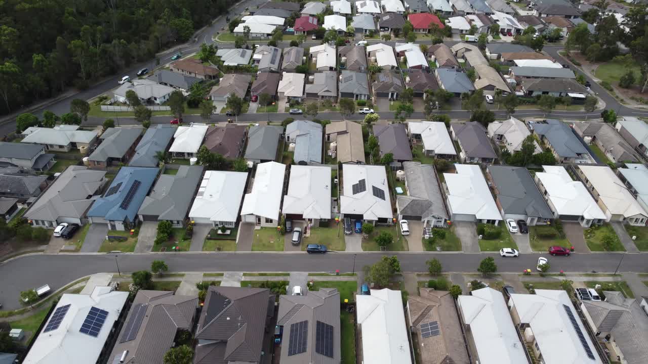 drone descendiendo en un tranquilo barrio australiano con densas casas privadas y tranquilas calles suburbanas