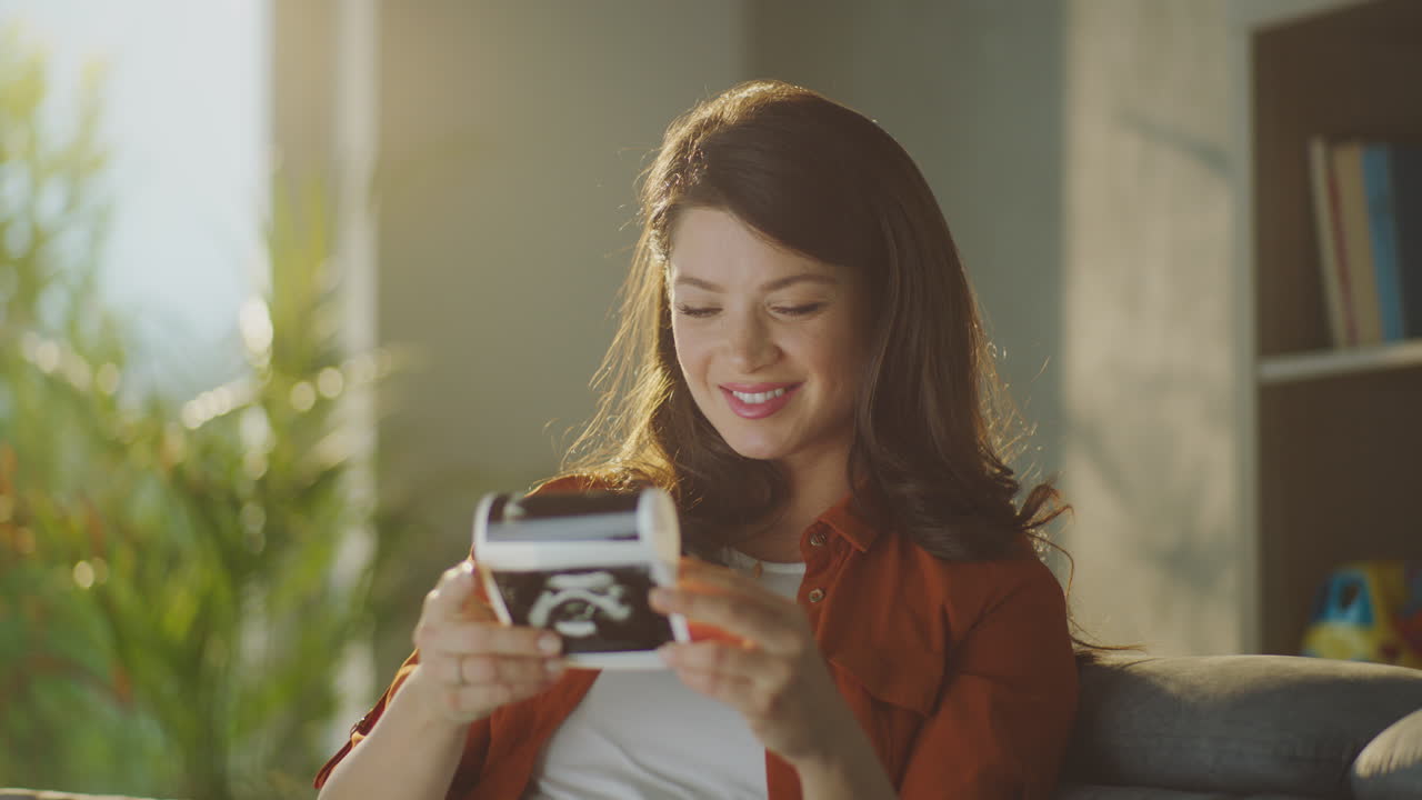 Pregnant woman looking at ultrasound photo