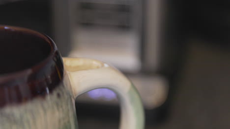 un chorro de leche vertida en café humeante y luego revuelto