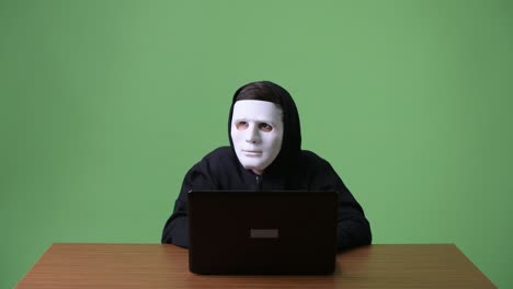 young teenage boy computer hacker against green background