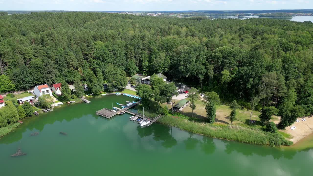 드론에서 볼 수 있는 호수와 관광 리조트. 물, 숲, 건물의 전망