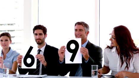 Business-people-on-interview-panel-showing-scores