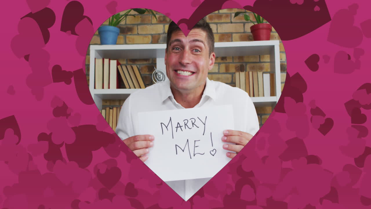 비디오 통화로 청혼하는 백인 남성 위에 분홍색 심장이 있는 심장 모양의 프레임의 애니메이션