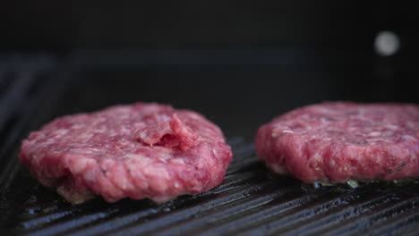 Langsame-Pfanne-Rechts-Von-Vier-Burger-Pastetchen,-Die-Auf-Einem-Grill-Brutzeln