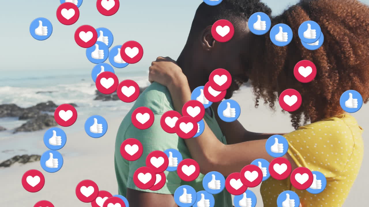 corazón y como iconos flotando contra una pareja afroamericana abrazándose en la playa