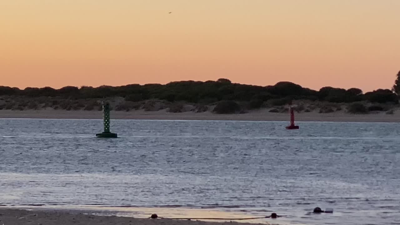sanlucar de barradema, cadiz, guadalquivir, rio, doñana, españa, Floating buoys and distant trees at twilight on a tranquil shore