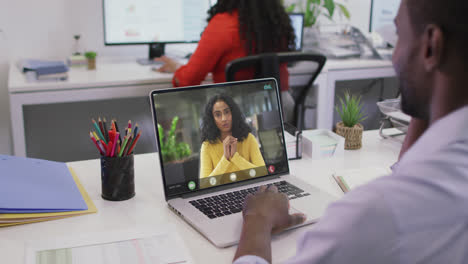 Video-of-african-american-man-having-video-call-on-laptop-with-biracial-female-coworker