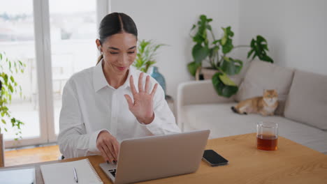 friendly businesswoman greeting computer at remote office. woman studying online