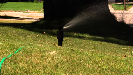 Se-Muestra-Un-Rociador-Regando-El-Césped-En-Un-Cálido-Día-De-Verano