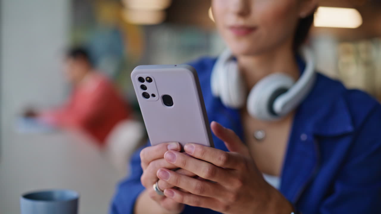 Student hands messaging cellphone in cozy coffee shop closeup. Smiling brunette