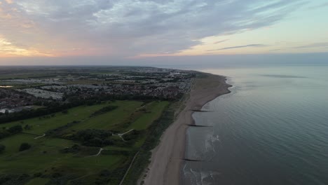 aerial view of coastal town, beach, and golf course at dusk