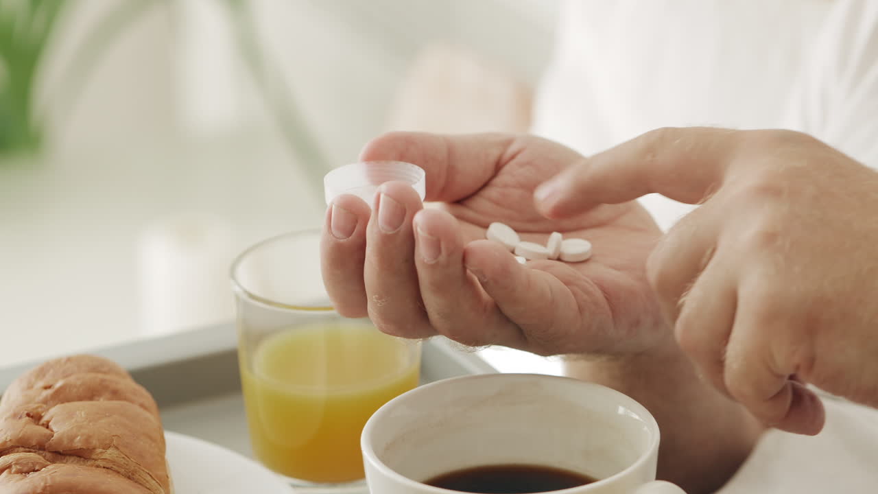 Person's Hands Taking Pills During Morning Breakfast Routine
