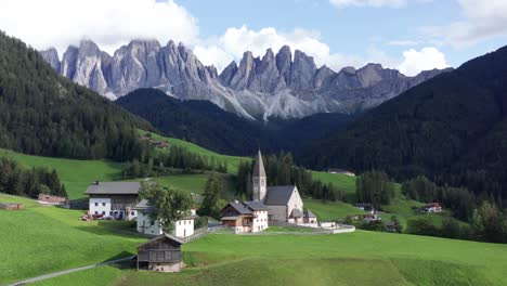 pequeño pueblo de montaña con iglesia bajo las montañas dolomitas en italia, val di funes antena