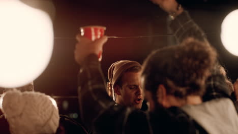 multi ethnic group of friends having fun dancing to music on rooftop at night enjoying celebration party