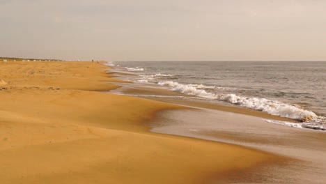 An-Einem-Bewölkten-Tag-Schlagen-Wellen-Am-Goldenen-Sandstrand