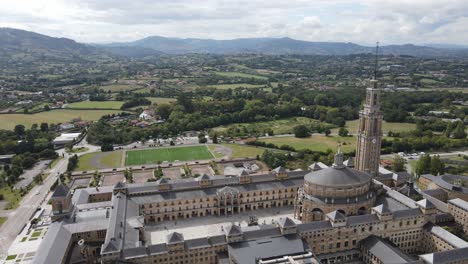 aerial flyover of la laboral in gijon surrounded by lush summertime countryside