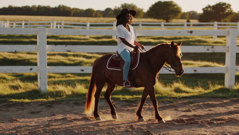 a woman horseback riding at sunset
