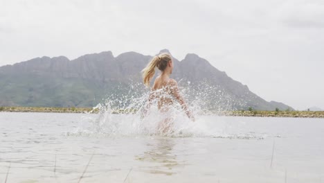 Mujer-Caucásica-Pasando-Un-Buen-Rato-En-Un-Viaje-A-Las-Montañas,-Usando-Traje-De-Baño-Y-Parada