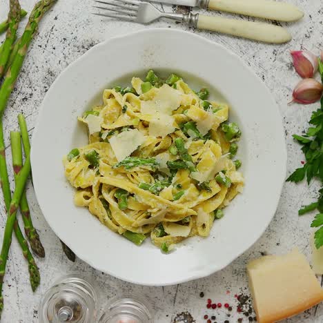 Pasta-Casera-De-Tallarines-Con-Cremosa-Salsa-De-Queso-Ricotta-Y-Espárragos-Servida-En-Plato-De-Cerámica-Blanca