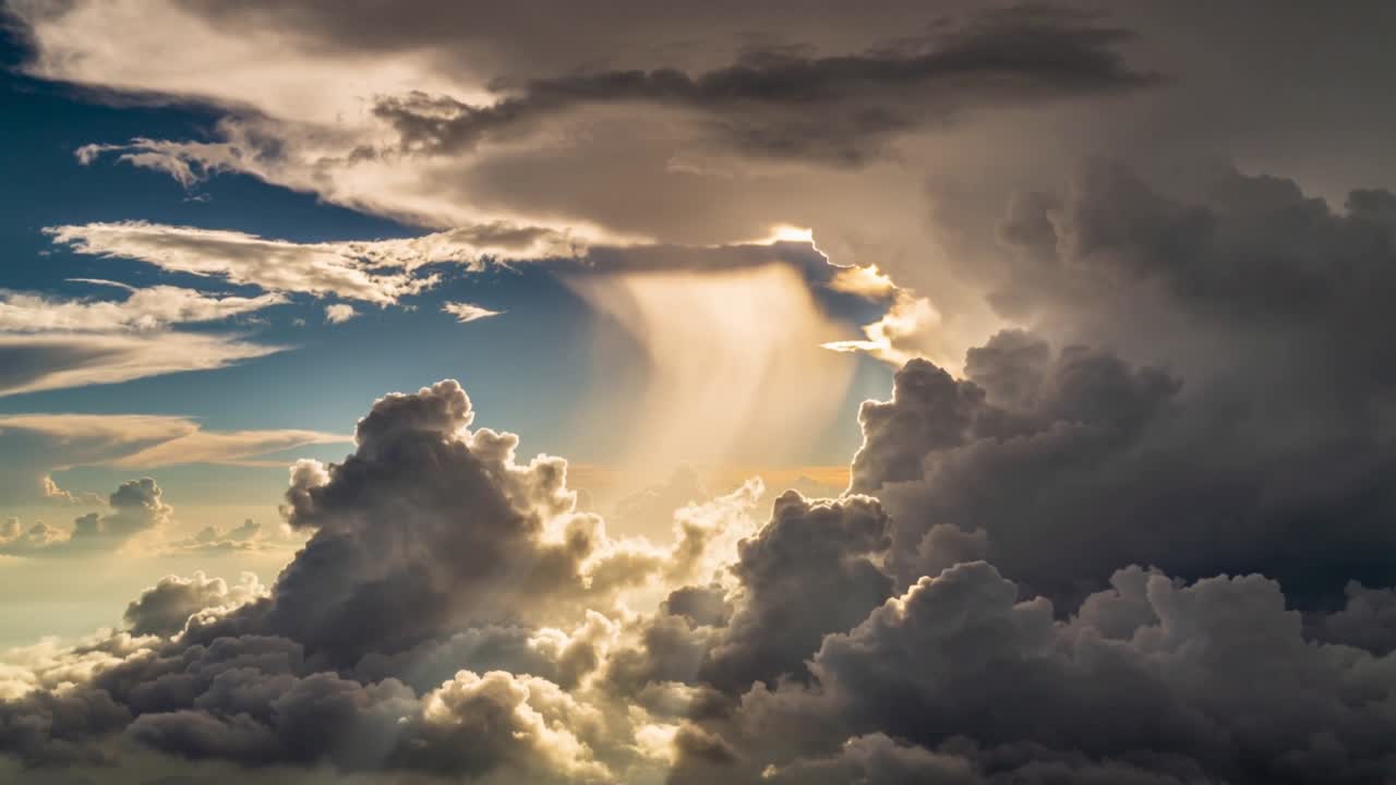 Scena meteorologica che mostra nuvole che si spostano mentre la luce solare filtra attraverso le nuvole superiori e illumina una colonna di luce.