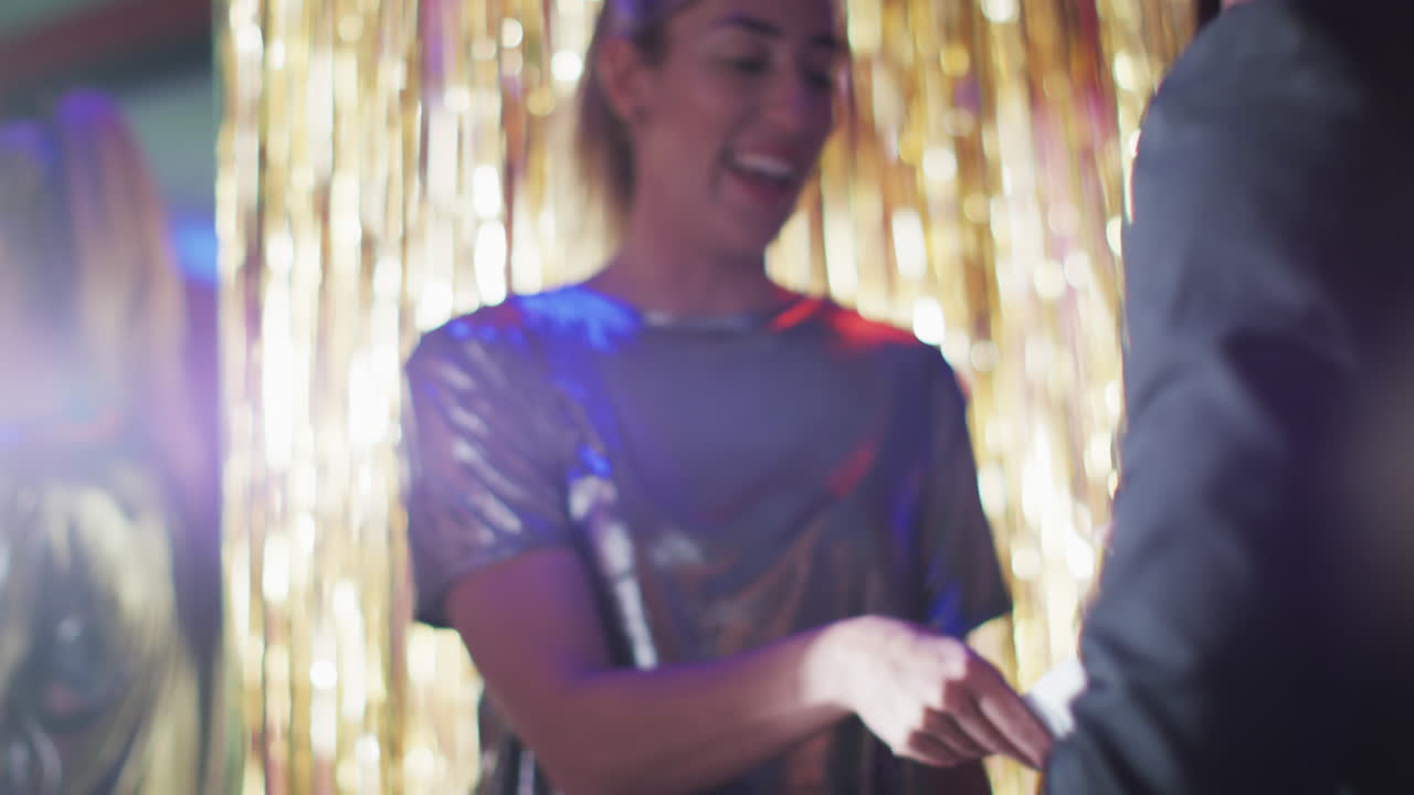 Video of diverse doorman greeting happy female friends walking into nightclub arm in arm laughing