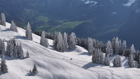 Drone-flies-over-majestic-mountain-and-cover-snow-and-town-near-mountain-at-Glarus,-Switzerland