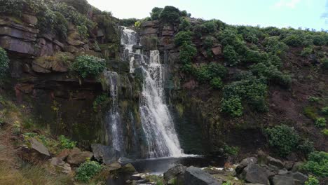 Aerial-drone-footage-of-a-tall-rocky-waterfall-in-the-Yorkshire-Dales,-Pennies