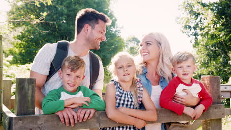 Slow-Motion-Portrait-Of-Family-Hiking-In-Lake-District-UK-Looking-Over-Wooden-Gate