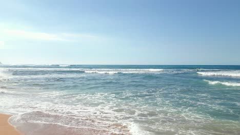 Summer-waves-rushing-to-the-island-beach-in-Oahu,-Hawaii--Low-aerial