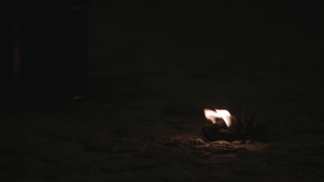 un pedazo de cuerda se quema en la noche en el pavimento
