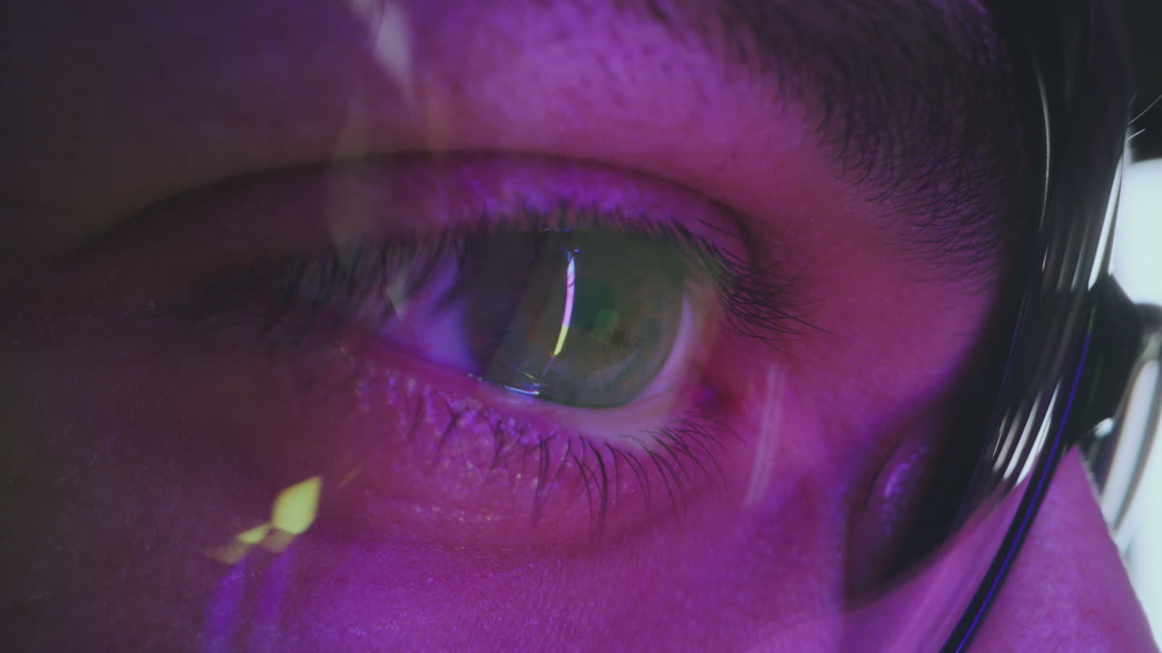 Close-up of a person's eye in purple light